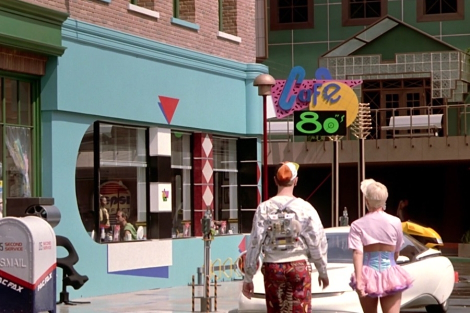 <p><strong>Figure 1.1</strong> After Marty survives the holographic shark attack, he spots the Cafe 80s, where Doc has sent him on a mission. The logo is displayed large on exterior signage, mounted on the front corner of the cafe.</p>