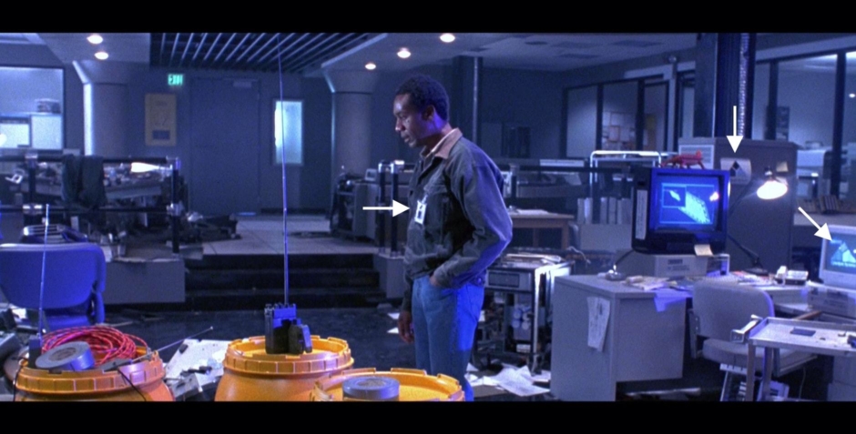 <p><strong>Figure 2.1</strong> In this scene, there are at least three instances (see arrows) of the Cyberdyne Systems logo — on Dyson’s employee badge, on the side of a computer cabinet and on a computer screen. This is an example of how extensively applied the identity is, though at times it is easy to miss.</p>