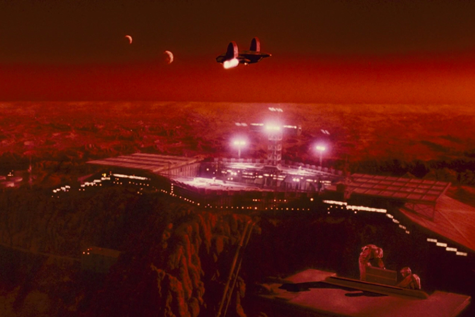 <p>A shuttle approaches the Mars colony, with its two moons in the sky overhead. The moons are featured prominently in the Federal Colonies logo. And with the Red Planet living up to its name, it’s also easy to see why red hues were used in all variations of this identity.</p>