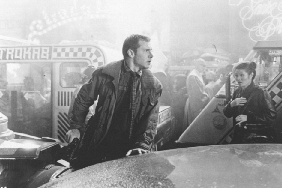 <p><strong>Figure 2.3</strong> Black and white production photo of Deckard in the street with Metrokabs in the background. Source: <em>Future Noir</em> Tumblr</p>