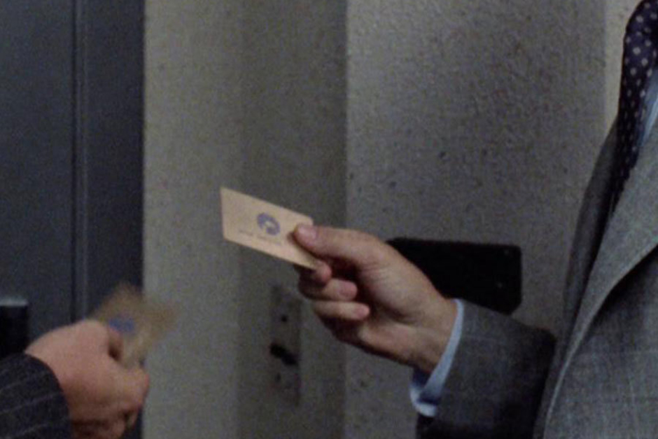 <p><strong>Figure 3.9</strong> Bob Morton and a colleague share a moment in front of the executive restrooms, where we get a glimpse of their gold OCP pass cards.</p>