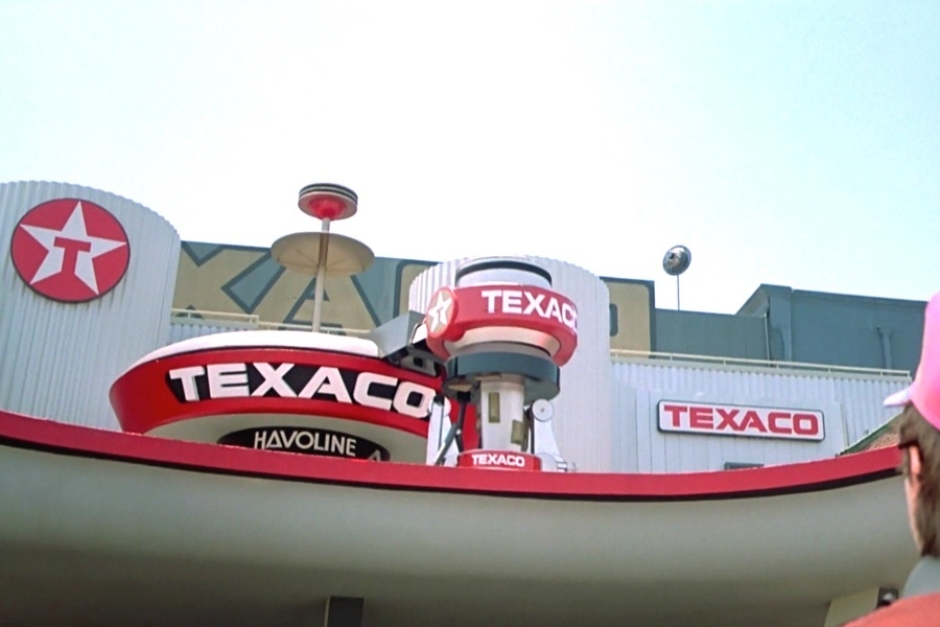 <p><strong>Figure 1.1</strong> As Marty takes in the town square of the future, he looks up to find a Texaco service station covered in logos — I count seven in this view alone.</p>
